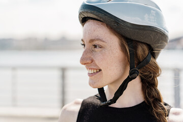 Portrait of a female athlete in a helmet with freckles on her face, a happy athlete during...
