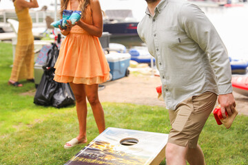 people playing cornhole, a popular American sport, representing camaraderie, outdoor leisure,...