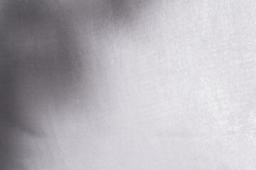 Blur shadow of leaves on white fabric. white cloth background soft wrinkled fabric patrem and surface