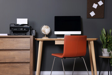 Stylish workplace with modern computer and printer at home