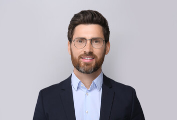Portrait of handsome man in glasses on light grey background