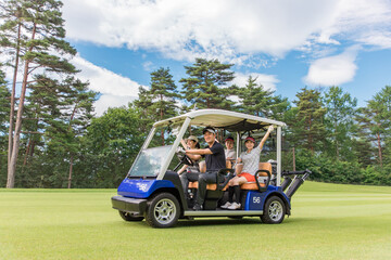 ゴルフ場でゴルフカートに乗るゴルファーの男女
