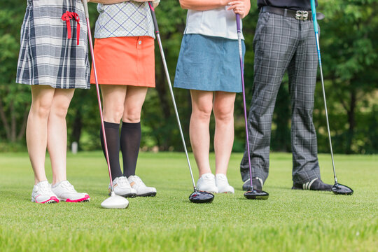 ゴルフに来た男女・ゴルフスクール・ゴルフレッスン・ゴルフ教室をする先生と生徒の足
