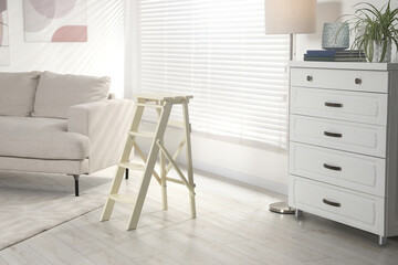 Folding ladder on wooden floor at home