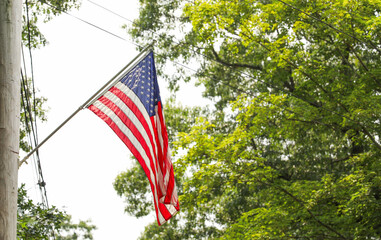 US flag waves proudly in front of an American home, representing the meaning and symbolism of...