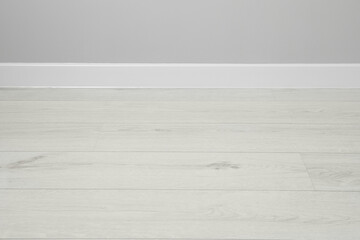 White plinth on laminated floor near wall indoors