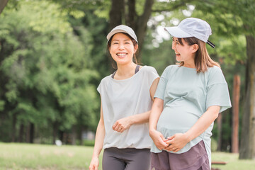 妊娠中に運動・ウォーキング・有酸素運動・散歩して話すプレママ・妊婦の女性・ママ友
