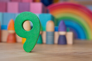 Wooden number nine on rainbow backdrop
