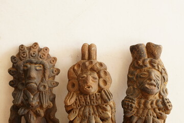 Mayan god clay statues on wooden and white background with copy text space