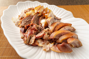 Fresh pork head meat in white porcelain dish on vintage background