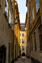 Fototapeta na wymiar Stockholm, Sweden A man walks on a narrow cobblestones street in Gamla Stan or Old Town on Ankargrand.