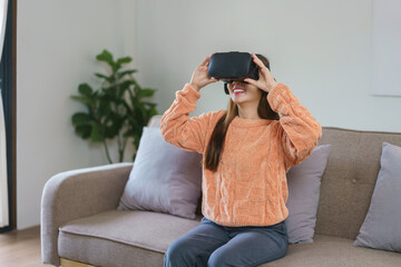 Obraz premium Women enjoying experience with virtual reality goggles to watch future world in lifestyle at home