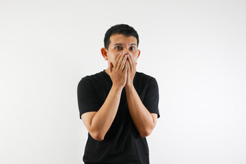 Adult Asian man showing shocked expression with his hands covering mouth