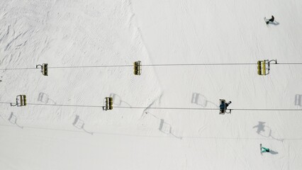 Aerial view of Livigno ski resort in Lombardy, Italy. Chairlifts, ski lifts, gondola cabin lifts are moving. View from above, top view. - obrazy, fototapety, plakaty