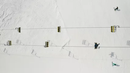 Fotobehang Gondels Aerial view of Livigno ski resort in Lombardy, Italy. Chairlifts, ski lifts, gondola cabin lifts are moving. View from above, top view.