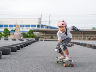 asian child skater or kid girl fun playing skateboard or smile riding carving surf skate on car...