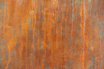 orange rust stains on weathered steel plate or yellow iron table and old brown metal wall by...