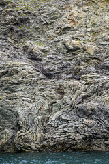 Interesting geologic feature in rock layers with colorful lichen, patterns and texture in nature, as a nature background

