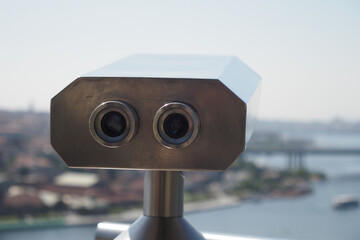 Coin-operated binoculars looking out over city ,