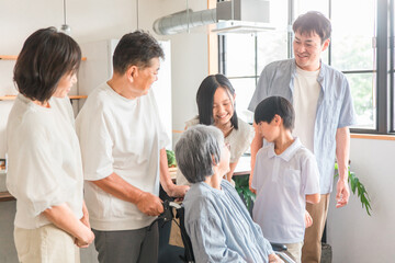 車椅子に座るおばあちゃんに会いに来た家族
