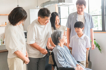 車椅子に座るおばあちゃんに会いに来た家族
