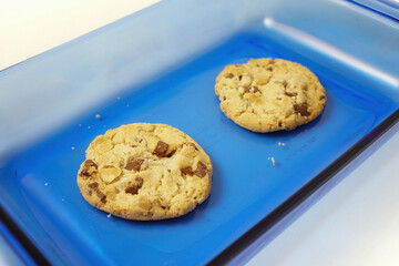Chocolate and nut cookies on blue glass plate