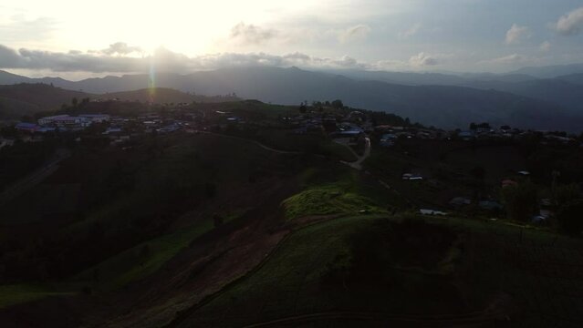 Aerial view of beautiful sunrise or sunset sky and rural villages. Village landscape in misty valley and mountain clouds in thailand.