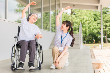 Fototapeta na wymiar 病院・介護施設で体操・運動・リハビリする車椅子に乗った高齢者と介護士（理学療法士・看護師） 