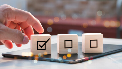 Placing wooden cube with checkmark on it. compliance and regulation. Management of quality control, ISO accreditation. Service, product quality guarantee. procedure of assessment, survey checklists.