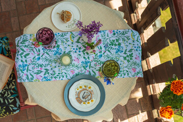 Table on the terrace with soft drinks, flowers and a plate of daisies