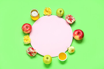Composition with blank card, ripe fruits, honey and flowers on green background. Rosh hashanah (Jewish New Year) celebration