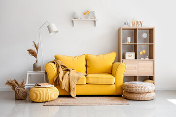 Interior of light living room with stylish yellow sofa and soft poufs