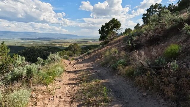 Driving down rocky forest mountain road Utah POV. Off road trail riding in 4x4 all terrain vehicle for sport and recreation. Red rocks and sand, dry arid landscape. Rocky terrain and sand dunes. Fun.