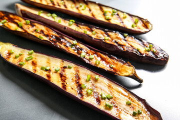 Delicious grilled eggplants on grey background, closeup