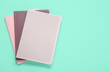 Different colorful notebooks on turquoise background