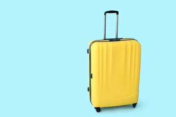 Yellow suitcase on blue background. Travel concept