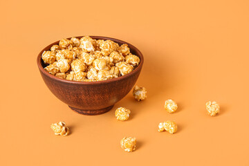 Bowl with tasty popcorn on brown background