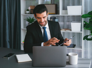 Professional businessman in black suit, present financial data or BI paper via laptop during online meeting. Remote work concept with virtual meeting presentation of effectiveness remote work. Fervent