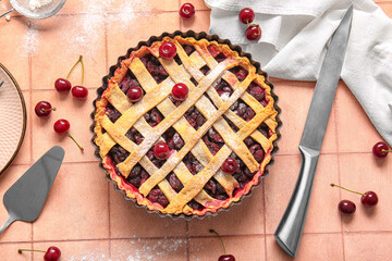 Baking dish with tasty cherry pie on pink tile background