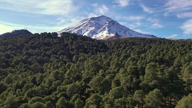 vuelo a&eacute;reo que va descubriendo el volc&aacute;n Popocat&eacute;petl entre el bosque.