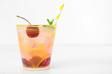 Glass of tasty cherry lemonade with mint on white background