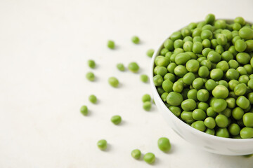 Bowl with fresh green peas on white background