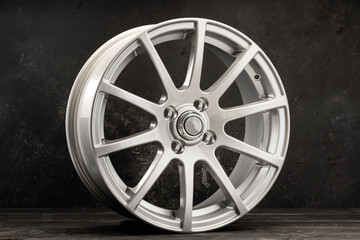 silver alloy wheels lightweight auto parts with many spokes on a dark textured background