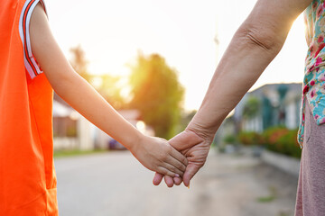parent holds the hand of a small child