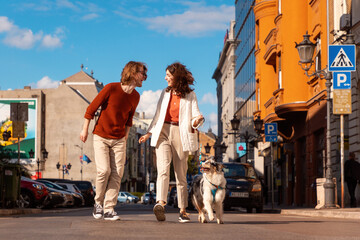 Young Caucasian couple with pet walking to the city. Training purebreed aussie dog