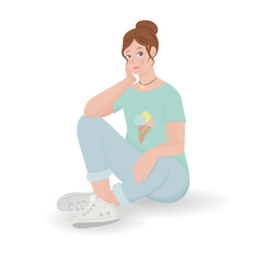 A fair-haired girl sits on the floor with one leg bent in jeans and a blue T-shirt with ice cream