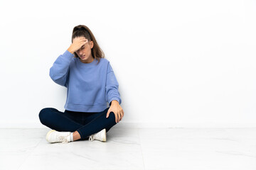Fototapeta premium Young woman sitting on the floor with headache