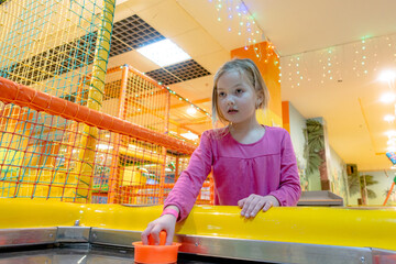 Girl playing air hockey in the children's playroom