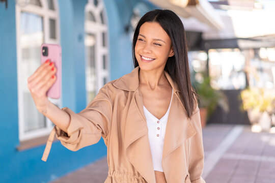 Young woman at outdoors making a selfie with mobile phone