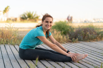 Fototapeta na wymiar Young woman at outdoors doing yoga